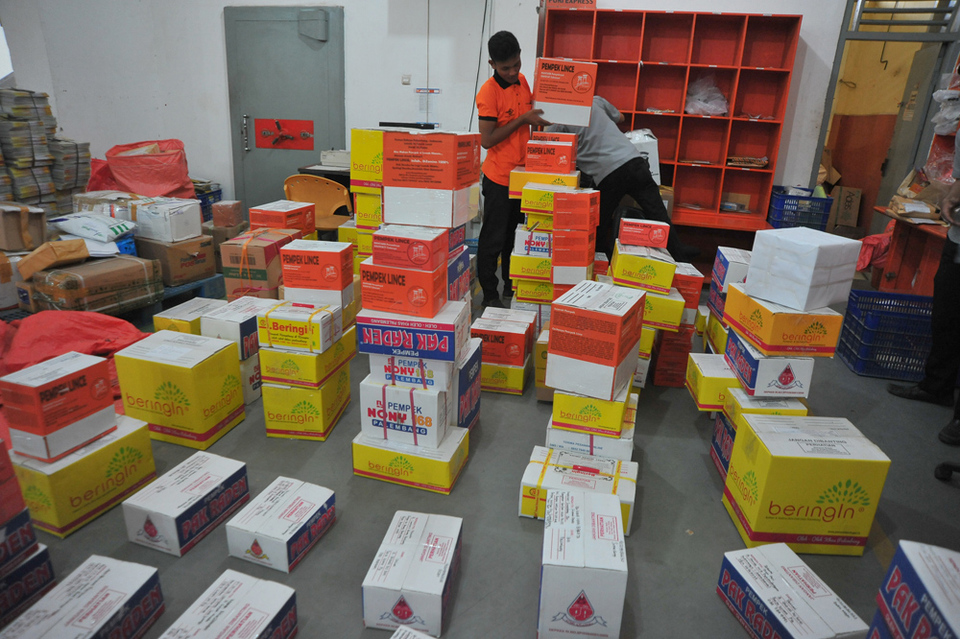A postal worker at Pos Indonesia stacks parcels for delivery at a post office in Palembang, South Sumatra on Jun 21, 2021. (Antara Photo/Feny Selly)