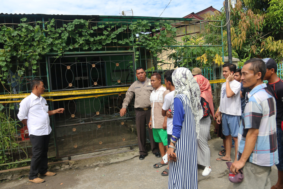 Residents gathering outside the house of on of the men allegedly involved in an attack on police in Medan, North Sumatra, on Sunday (25/06). (Antara Photo/Irsan Mulyadi)