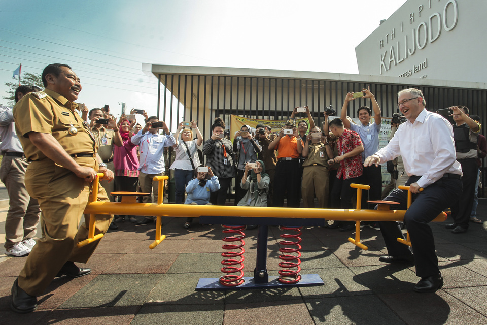 Rotterdam Mayor Ahmed Aboutaleb, right, trying out the seesaw with West Jakarta Mayor Anas Effendi during his visit to the Kalijodo Open Public Space Area in West Jakarta on Monday (12/06). (Antara Photo/Muhammad Adimaja)