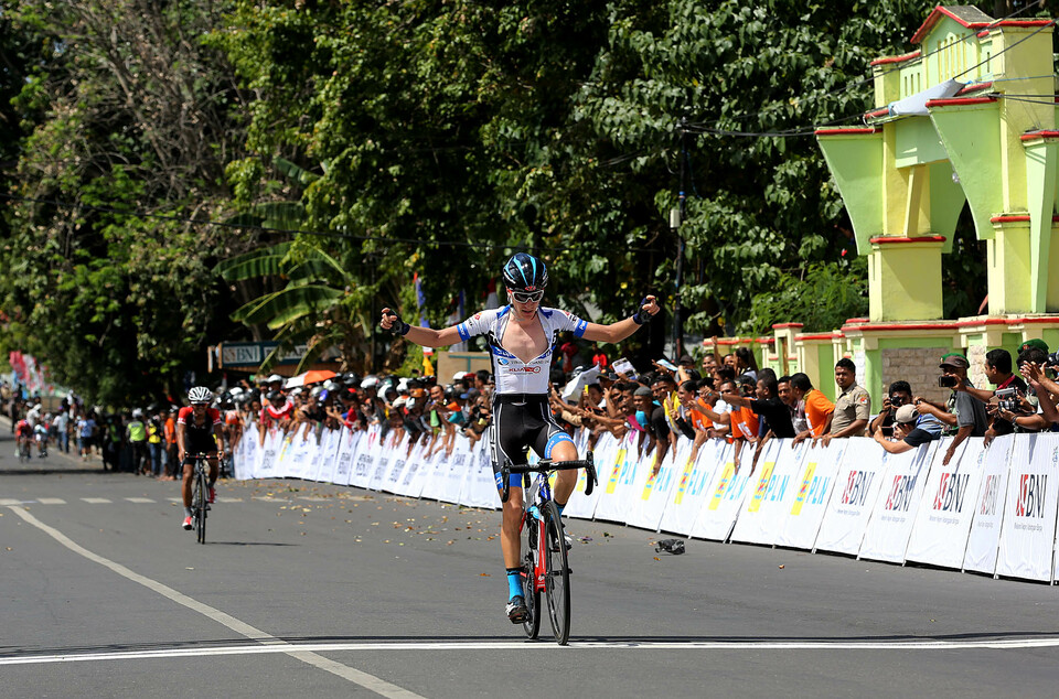 Australian rider Drew Morey of Terengganu Cycling Team arrives at the finish line in Maumere, winning the opening stage of the Tour de Flores on Friday (14/07).  (Photo courtesy of the Tour de Flores)