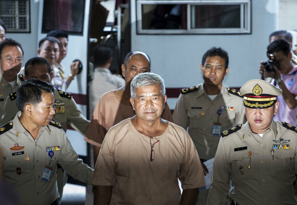 Lieutenant General Manas Kongpan, center, a suspected human trafficker, is escorted by officers as he arrives at the criminal court in Bangkok in November 2015. (Reuters Photo/Athit Perawongmetha)