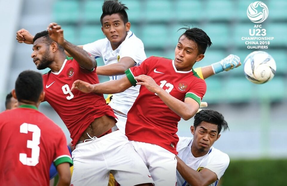 Indonesian players in an aerial duel with Malaysia during an AFC U-23 Championship pre-qualifier on Wednesday (19/07). (Photo courtesy of Twitter/Asian Football Confederation)