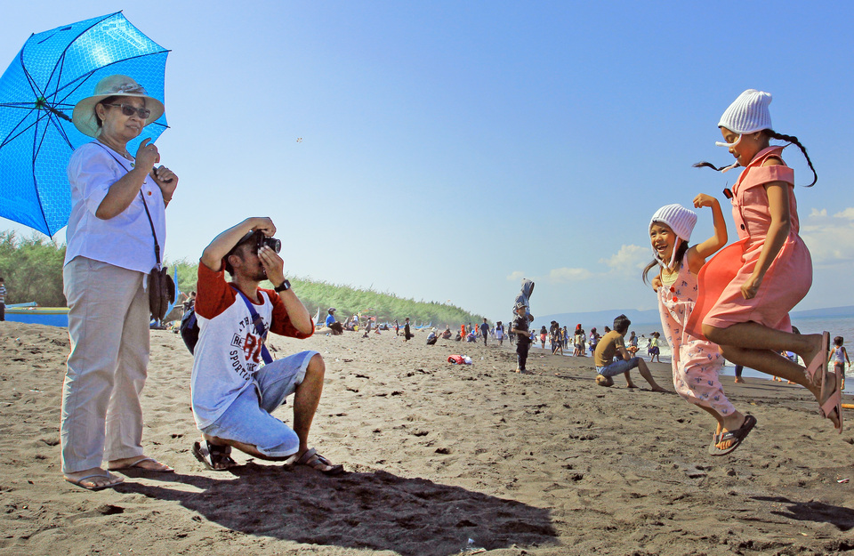 Visitors enjoying themselves on Cemara Beach in Banyuwangi, East Java, in this July 2 file photo. Flag carrier Garuda Indonesia will commence direct flights from Jakarta to Blimbingsari Airport near Banyuwangi in August. (Antara Photo/Budi Candra Setya)