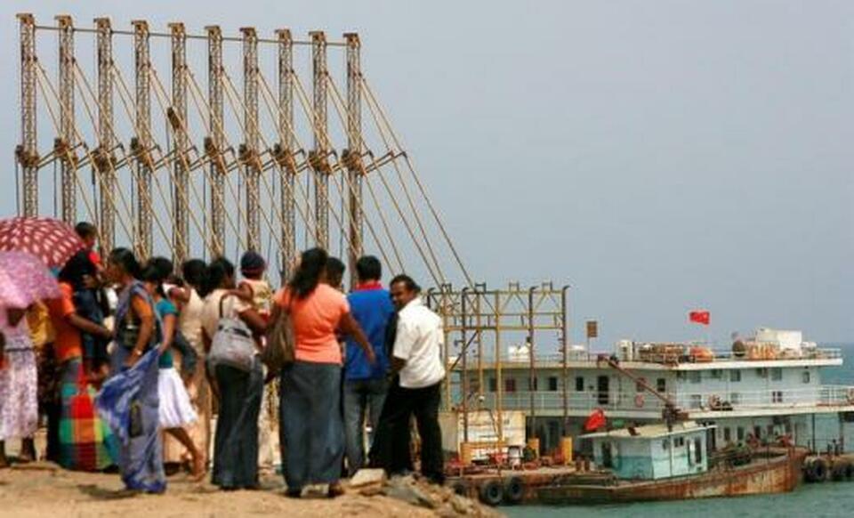 A group of Sri Lankan visitors at the new deep water shipping port watch Chinese dredging ships work in Hambantota, 240 km (150 miles) southeast of Colombo, March 24, 2010.   (Reuters Photo/Andrew Caballero-Reynolds)