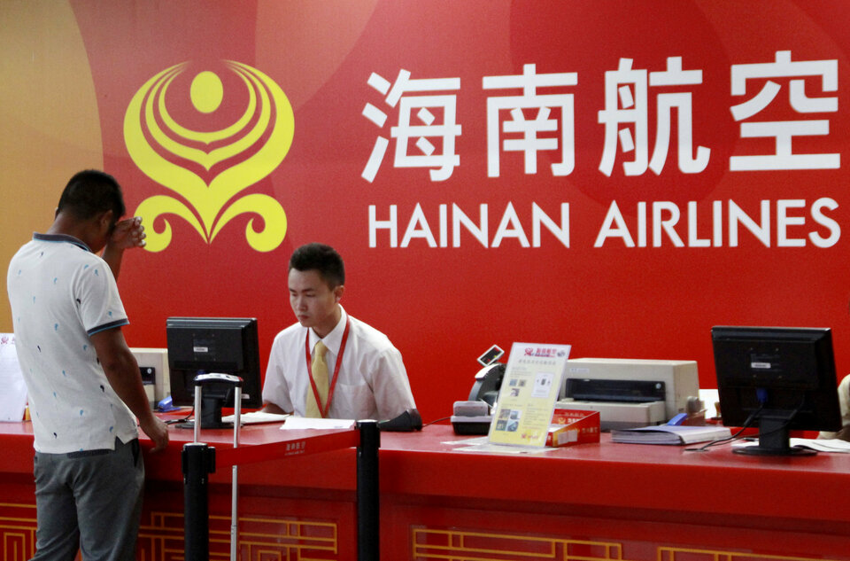 A customer stands in front of a Hainan Airlines counter at an airport in Haikou, China, in this July 2014 file photo. (Reuters Photo)