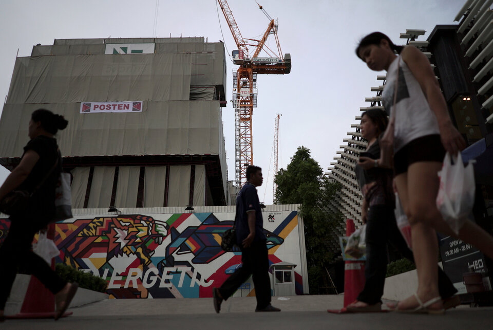People walk past an under-construction site of a condominium in Bangkok, Thailand, Tuesday (01/08). (Reuters Photo/Athit Perawongmetha)