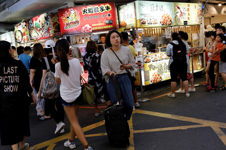 Tourists walk near food stalls at Ximending shopping district in Taipei, Taiwan, on Aug. 3, 2017. (Reuters Photo/Tyrone Siu)