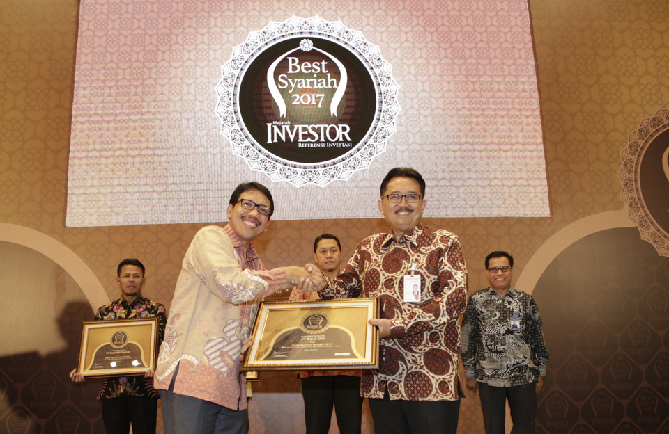 Business Director of Bank DKI, Antonius Widodo Mulyono (right) and Head of the Department of Islamic Economics of Bank Indonesia, Anwar Basori (left) received the award of Sharia Banking Unit as "Best Sharia Bank 2017" category of Sharia Asset Business Unit More than Rp 1 trillion - 5 Trillion from Investor magazine in Jakarta, August 22, 2017. Bank DKI has 22 service offices spread across Jakarta and West Java. Sharia Services can also be done in all conventional Bank DKI office. Courtesy photo of Bank DKI