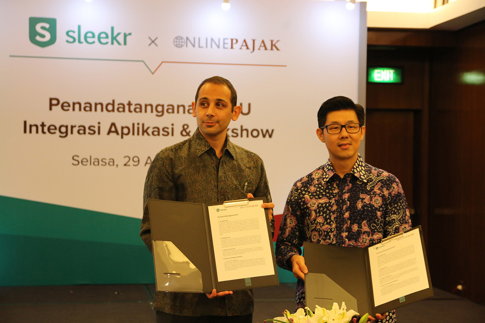 OnlinePajak director Charles Guinot, left, poses with Sleekr chief executive Suwandi Soh after signing a memorandum of understanding in Jakarta on Tuesday (29/08). (Photo courtesy of Sleekr and OnlinePajak)