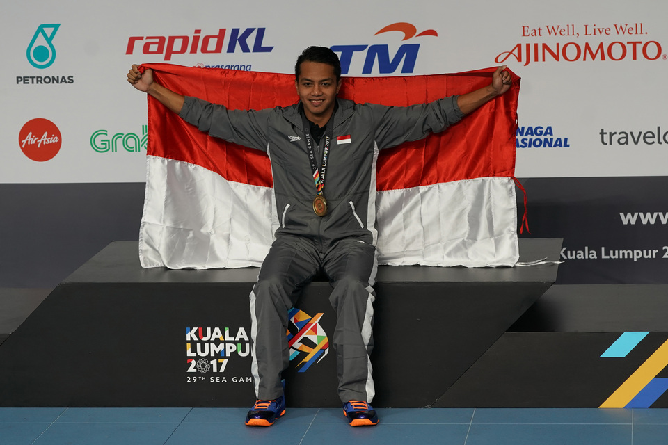 Jakarta-based swimmer I Gede Siman Sudartawa poses with the national flag after winning a gold medal at the 2017 Southeast Asian Games in Kuala Lumpur on Monday (21/08). (Antara Photo/Sigid Kurniawan)