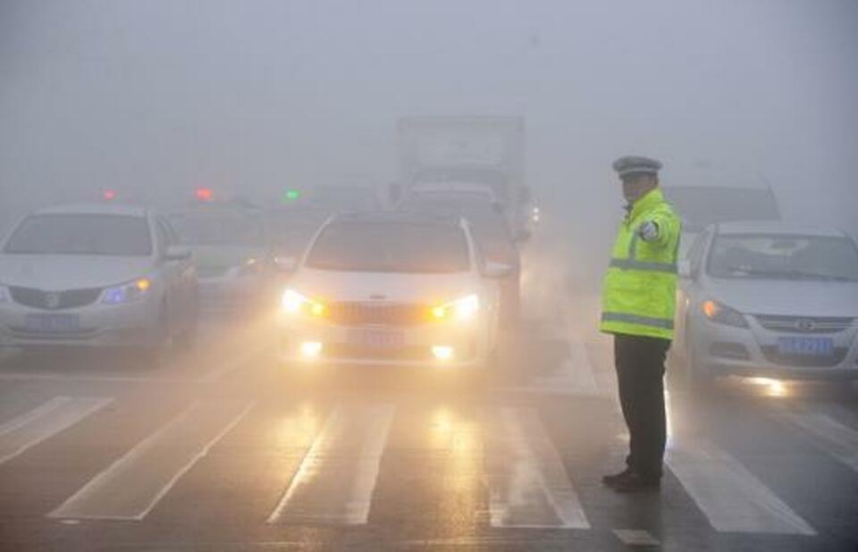 A traffic police officer works among heavy smog during a polluted day in Bozhou in China's Anhui province in this February 2017 file photo. (Reuters Photo)