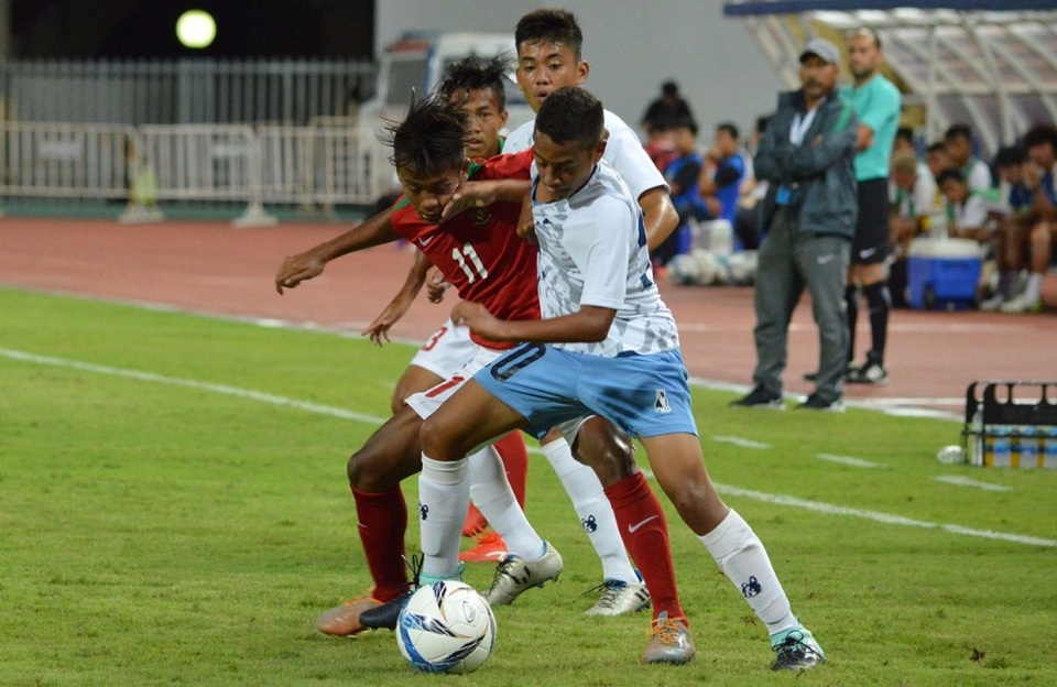Indonesia's U-16 player Mochammad Supriadi (number 11) fights for the ball with Northern Mariana Islands players as coach Fakhri Husaini looks on. (Photo courtesy of the Indonesian Football Association PSSI)