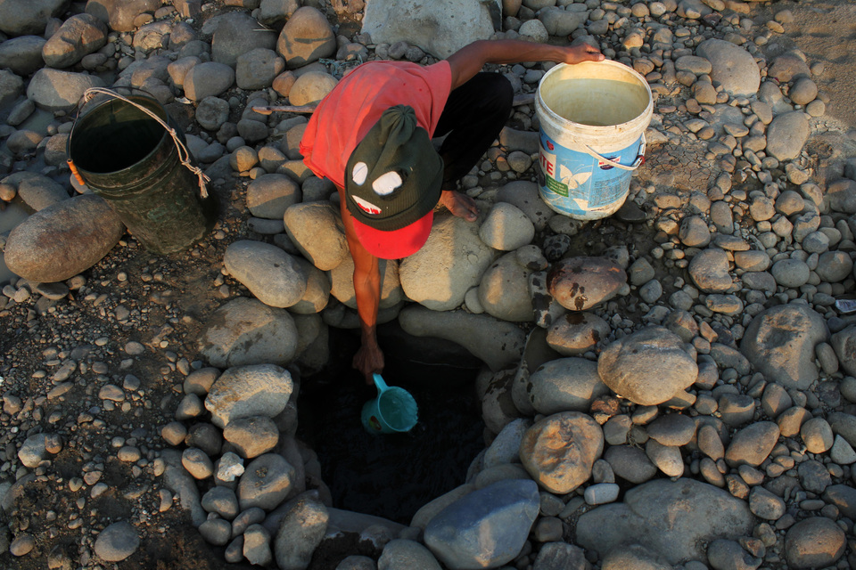 This file photo from 2017 shows a resident extracting water from a well on the banks of the Cipamingkis River in Bekasi, West Java during a severe drought season that year. (Antara Photo/Risky Andrianto)