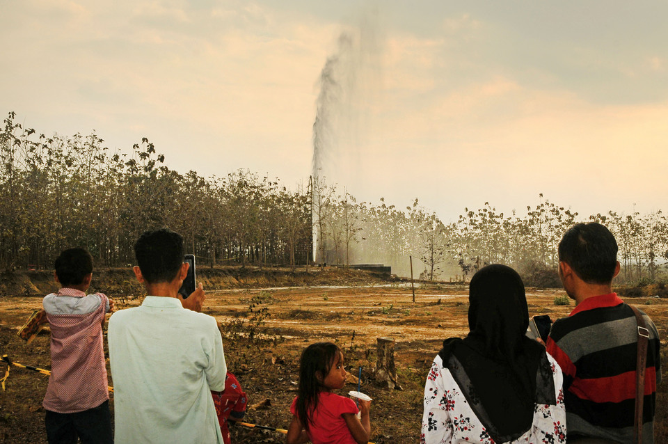 Residents watch as disused oil wells erupt in Botoreco Village, Central Java on Monday (25/09). (Antara Photo/Yusuf Nugroho)