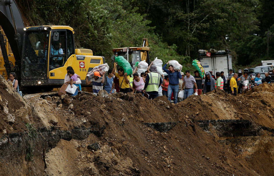 People traveling by bus for two days and were trapped between landslides walks in an area of a highway collapsed by Storm Nate in Casa Mata, Costa Rica October 6, 2017.  (Reuters Photo/Juan Carlos Ulate)