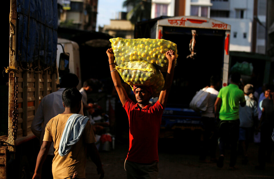 A worker carries sacks of limes at a vegetable market in Mumbai, India, October 12, 2017.  (Reuters Photo/Shailesh Andrade)