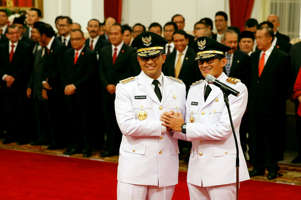 Anies Baswedan, left, and Sandiaga Uno assumed their duties as Jakarta governor and deputy governor for the next five years in a ceremony at the Presidential Palace on Monday (16/10). (Reuters Photo/Beawiharta)