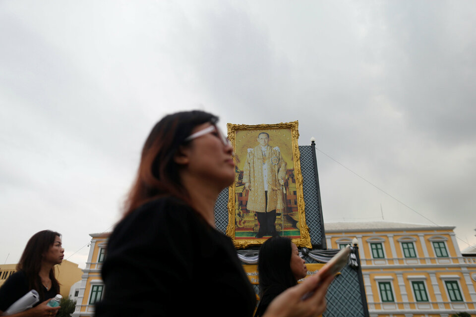 Women pass by the picture of late King Bhumibol Adulyadej in Bangkok, Thailand October 24, 2017.  (Reuters Photo/Soe Zeya Tun)