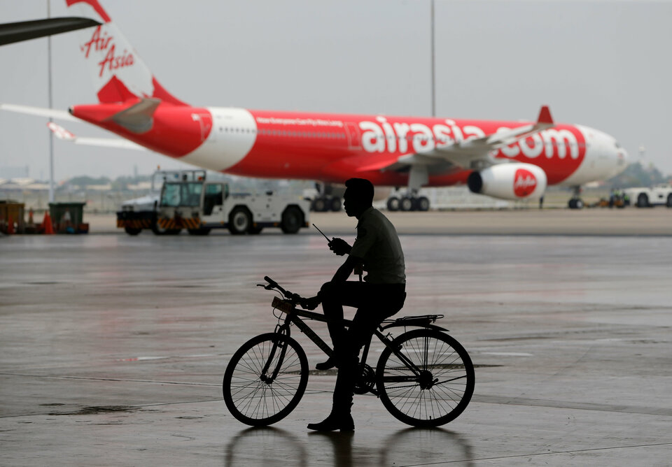 A security guard rides a bicycle past an AirAsia plane at the Garuda Maintenance Facility AeroAsia in Tangerang, Indonesia, September 20, 2017.  (Reuters Photo/Beawiharta)