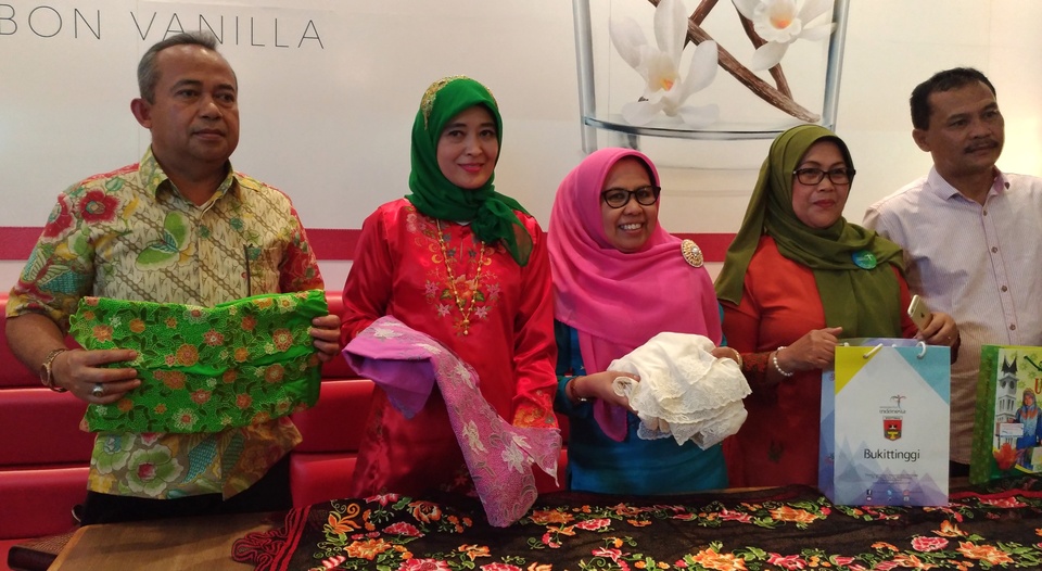 From left, Erwin Umar, Bukittinggi head of tourism, youth and sport, Yessi Endriani, chairwoman of the National Craft Council (Dekranasda) in Bukittinggi and Dekranasda Bukittinggi secretary Taty Yasmarni posing with kerancang Bukittinggi embroideries during a press conference in Jakarta on Wednesday (27/09). (JG Photo/Sylviana Hamdani)