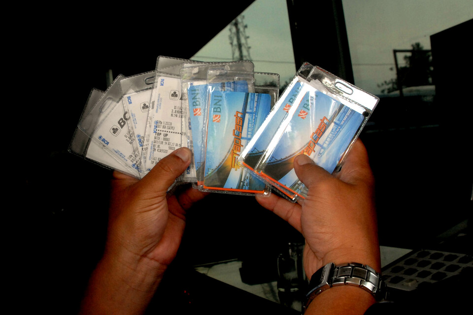 An official shows free e-money cards being given away at the Jagorawi toll gate in Bogor, West Java, on Monday (16/10). (Antara Photo/Yulius Satria Wijaya)