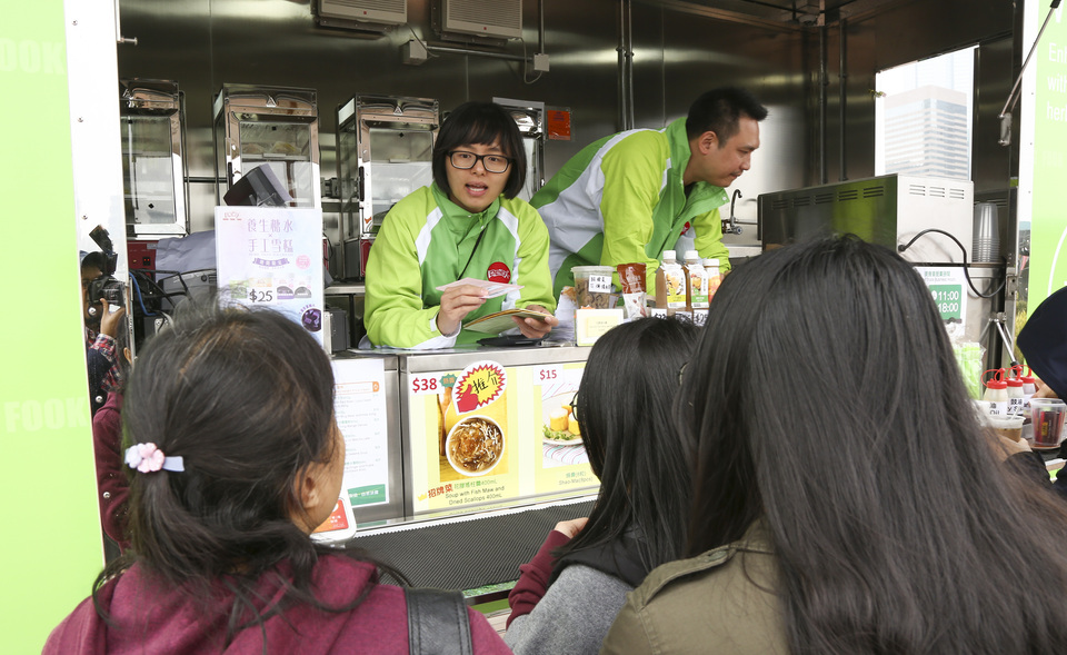 Staff members serve food at the Hung Fook Tong Food Truck, Central Harbourfront, Hong Kong, China, February 19, 2017. A brand new culinary experience has hit the streets in Asia. Sixteen food trucks have wheeled into Hong Kong for the first time ever - delighting diners with a menu of intriguing local street food delicacies and western classics, all with an innovative twist.  (Reuters Photo/Hong Kong Tourism Board)