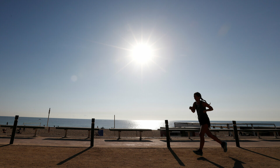 A woman exercises on a hot day in Barceloneta beach in Barcelona on Oct. 15, 2017. (Reuters Photo/Gonzalo Fuentes)