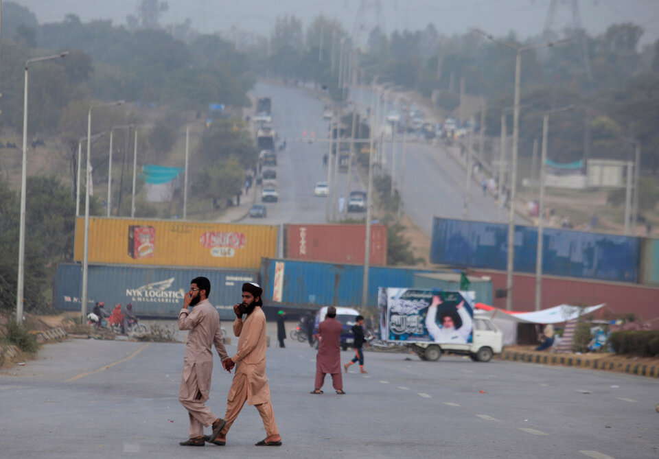 Men walk past a blocked highway as members of the Tehreek-e-Labaik Pakistan, an Islamist political party hold a sit-in in Rawalpindi, Pakistan November 13, 2017. (Reuters Photo/Faisal Mahmood)