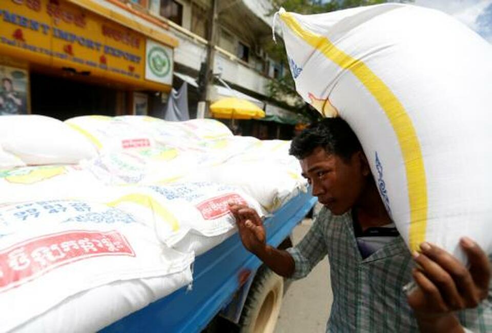 A man carries a sack of rice next to a truck in Phnom Penh, Cambodia, July 12, 2017.  (Reuters Photo/Samrang Pring)