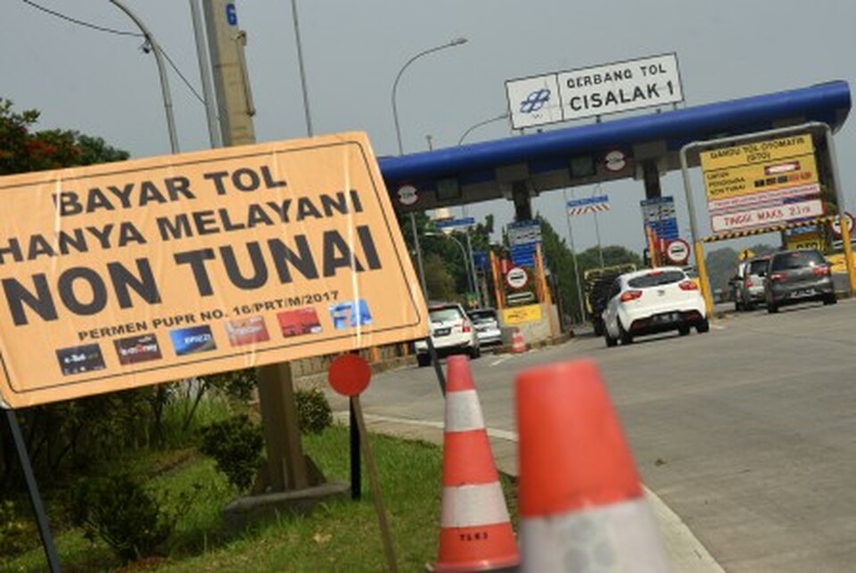 Motorists stop to pay toll fees at the Cisalak I gate on the Cinere-Jagorawi Toll Road in Depok, West Java, on Tuesday (31/10). State-controlled toll road operator Jasa Marga earlier announced that as of Tuesday, all toll gates in Indonesia would simultaneously only allow non-cash transactions. (Antara Photo/Indrianto Eko Suwarso)