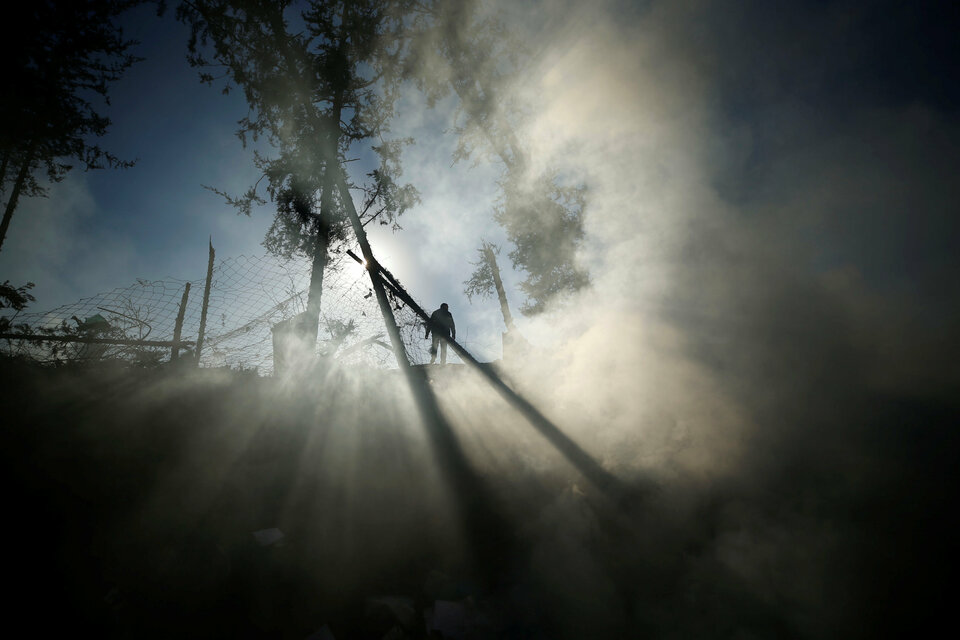 Smoke is seen as a Palestinian man inspects a militant target that was hit in an Israeli airstrike in the northern Gaza Strip December 9, 2017.  (Reuters Photo/Mohammed Salem)
