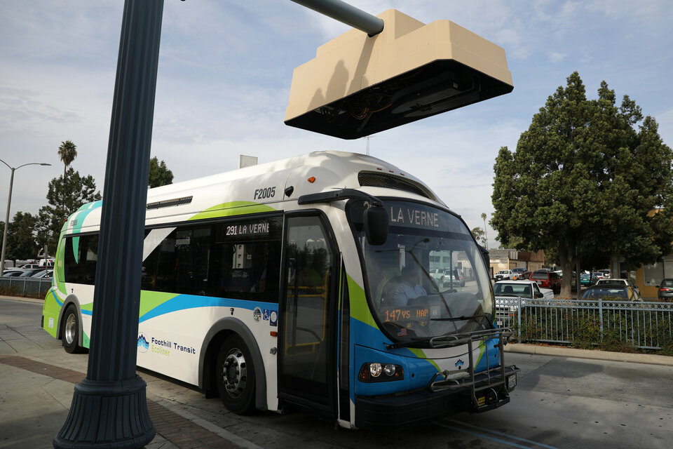 An electric bus sits under a charging station in Pomona, California, on Nov. 16. (Reuters Photo/Lucy Nicholson)