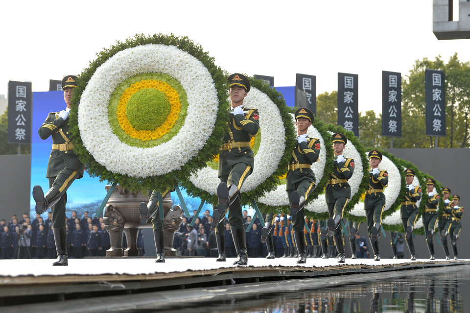 Paramilitary policemen carry wreaths as they march during a memorial ceremony to mark the 80th anniversary of the 1937 Nanjing Massacre, on the national memorial day in Nanjing, Jiangsu province December 13, 2017.  (Reuters Photo/Stringer)