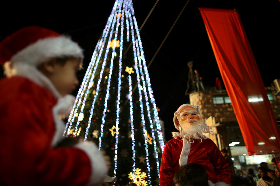 Boys wearing Santa Claus costumes are carried during a Christmas tree lighting ceremony in the northern town of Nazareth, the town of Jesus' boyhood, December 12, 2012. (Reuters Photo/Ammar Awad)