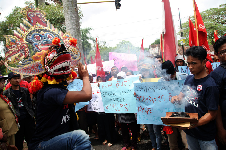 An activist wears a traditional barongan mask during a rally on Anti-Corruption Day in Blitar, East Java, on Monday (11/12). (Antara Photo/Irfan Anshori)