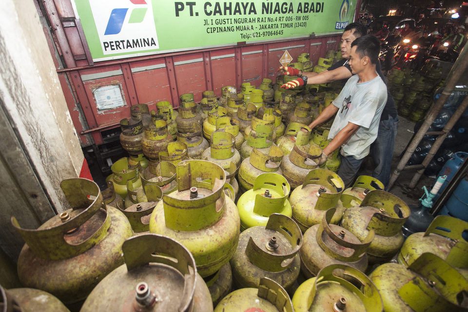 FILE - A worker lines up 3-kilogram LPG cylinders for distribution in Jakarta on Friday, Dec. 29, 2017.(Antara Photo/Muhammad Adimaja) 