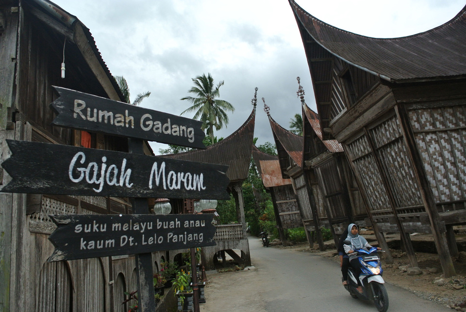 A motorcyclist drives through the Seribu Rumah Gadang area in Nagari Koto Baru, West Sumatra, on Wednesday (06/12). As many as 40 Minangkabau traditional houses, or rumah gadang, in the tourist destination will be restored by the Ministry of Public Works. (Antara Photo/Iggoy el Fitra)