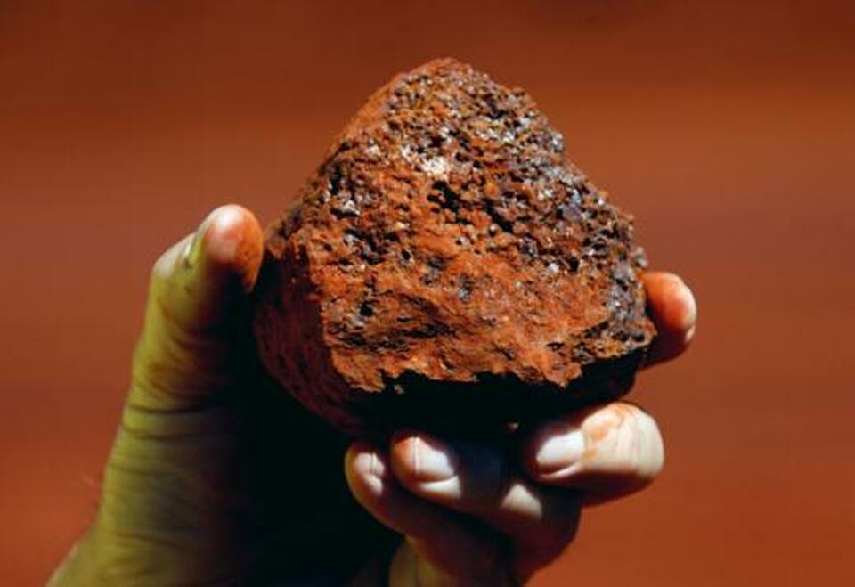 A miner holds a lump of iron ore at a mine in the Pilbara region of Western Australia. (Reuters Photo/David Gray)