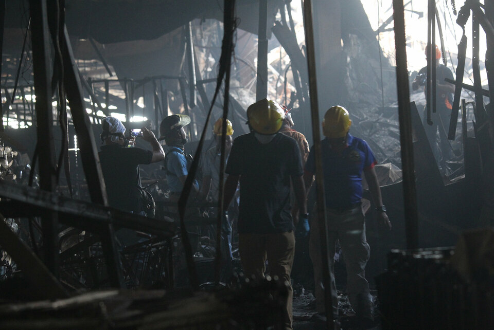 Fire investigators inspect the New City Commercial Center mall in Davao City in the Philippines after it was gutted by fire on Dec. 23. (Reuters Photo/Lean Daval Jr)