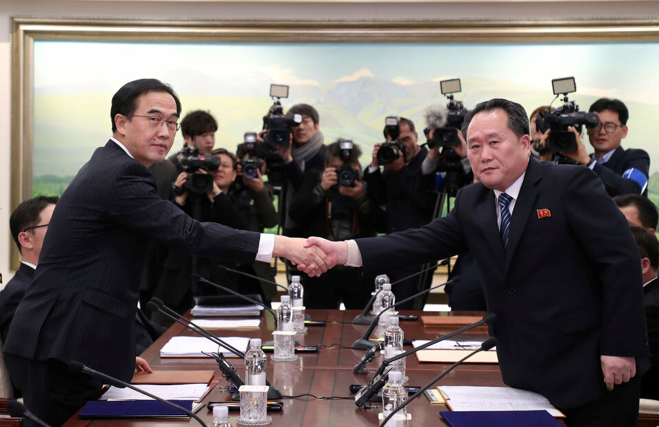 Head of the North Korean delegation, Ri Son Gwon shakes hands with South Korean counterpart Cho Myoung-gyon as they exchange documents after their meeting at the truce village of Panmunjom in the demilitarized zone separating the two Koreas, South Korea, January 9, 2018.   (Reuters Photo/Yonhap)