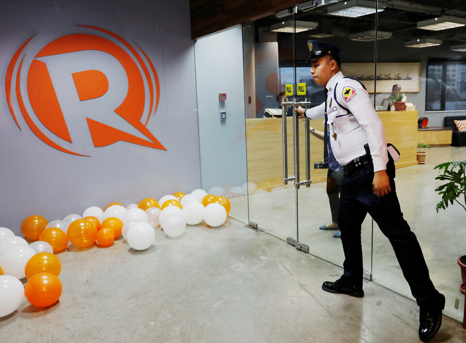 A guard opens a door at Rappler's offices in Pasig, Metro Manila, on Monday (15/01). (Reuters Photo/Dondi Tawatao)