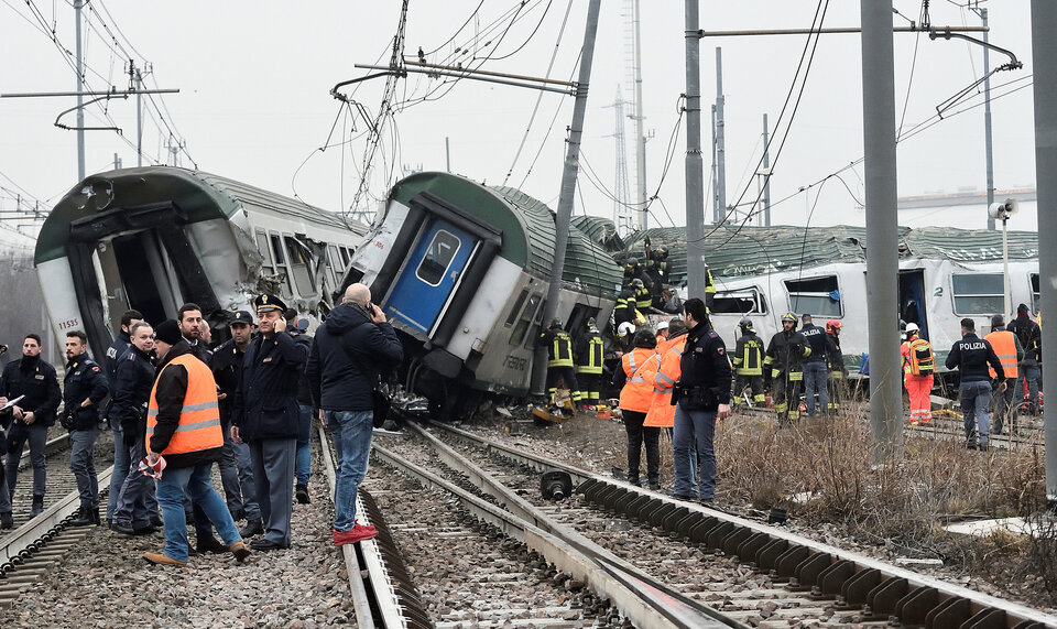 Rescue workers and police officers stand near derailed trains in Pioltello, on the outskirts of Milan, Italy, on Thursday (25/01). (Reuters Photo)
