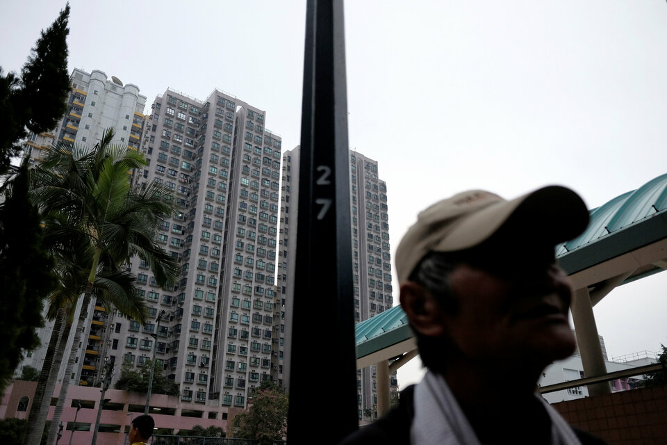 Cheung Muk-gun, 72, sits in front of residential buildings at a park in Hong Kong, China, Jan. 19. (Reuters Photo/Bobby Yip)