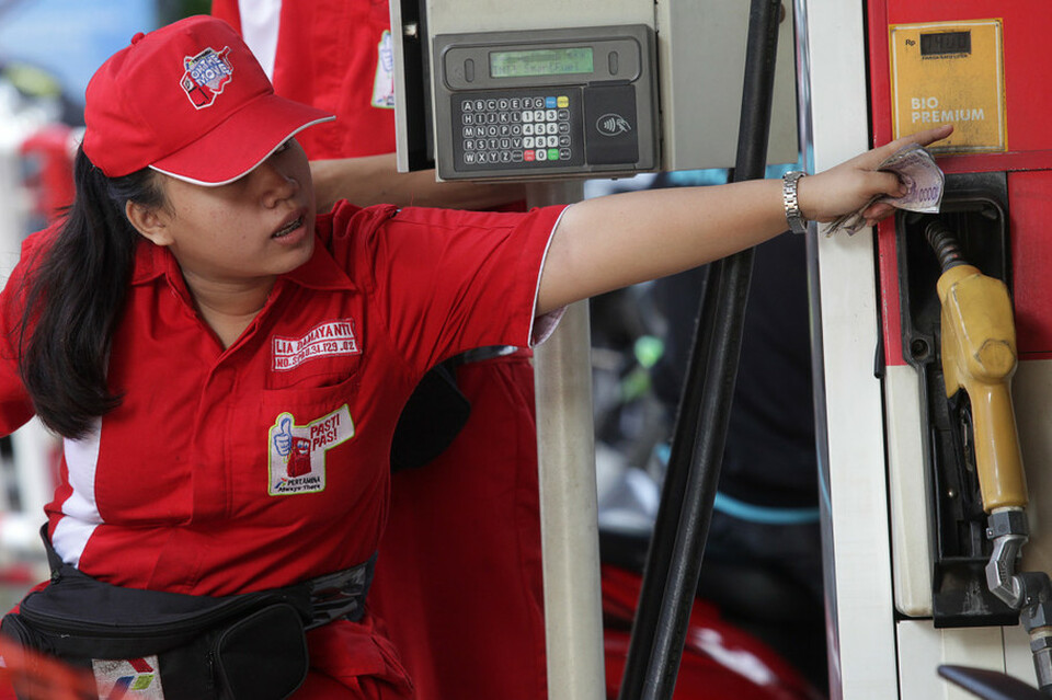 An attendant serves a customer at a Pertamina gas station in Jakarta. (ANTARA FOTO/Muhammad Adimaja).