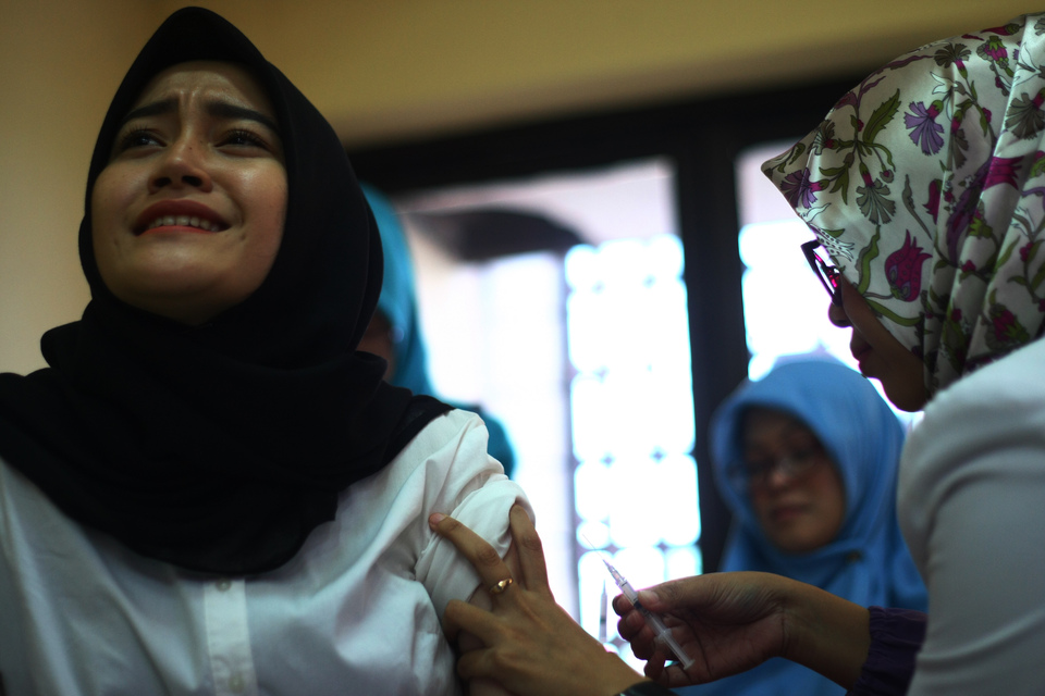 A student receives a diphtheria vaccination in Ciputat, Banten, on Dec. 27, 2017. (Antara Photo/Muhammad Iqbal)