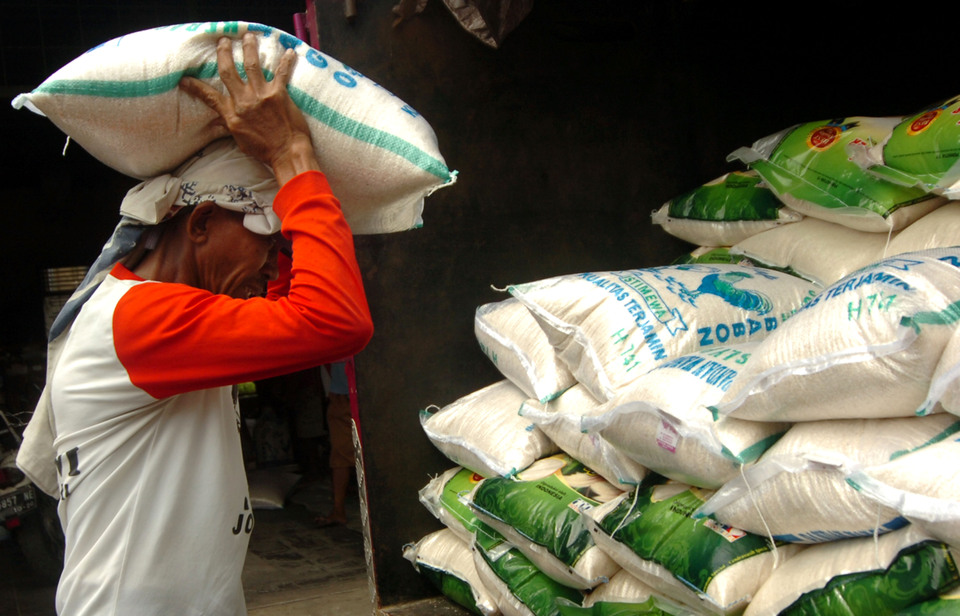 A worker carries a sack of rice at the Martoloyo Market in Tegal, Central Java, on Saturday (13/01). (Antara Photo/Oky Lukmansyah)

