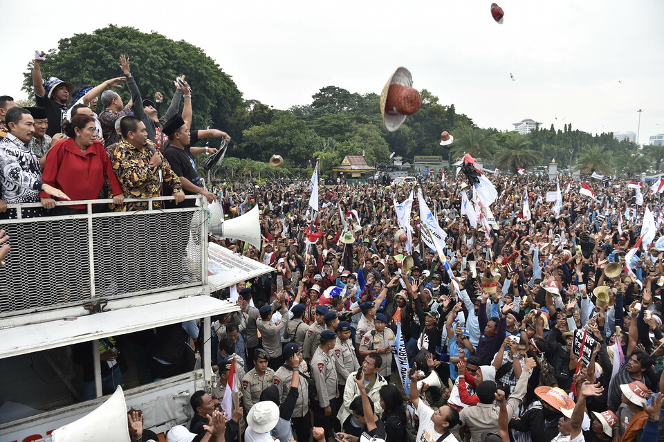 Indonesia's Maritime Affairs and Fisheries Minister Susi Pudjiastuti, second from left, addressed protesting fishermen in front of the Merdeka Palace in Jakarta on Wednesday (17/01). (Antara Photo/Puspa Perwitasari)