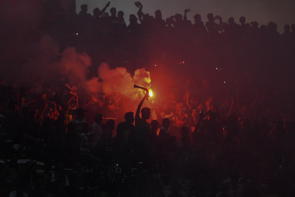 Persebaya Surabaya supporters light flares during a match against Madura United at Gelora Bung Tomo, Surabaya, East Java, on Sunday (28/01). The match broke the record of the 2018 Presidential Cup with an audience of 50,000. (Antara Photo/Zabur Karuru)