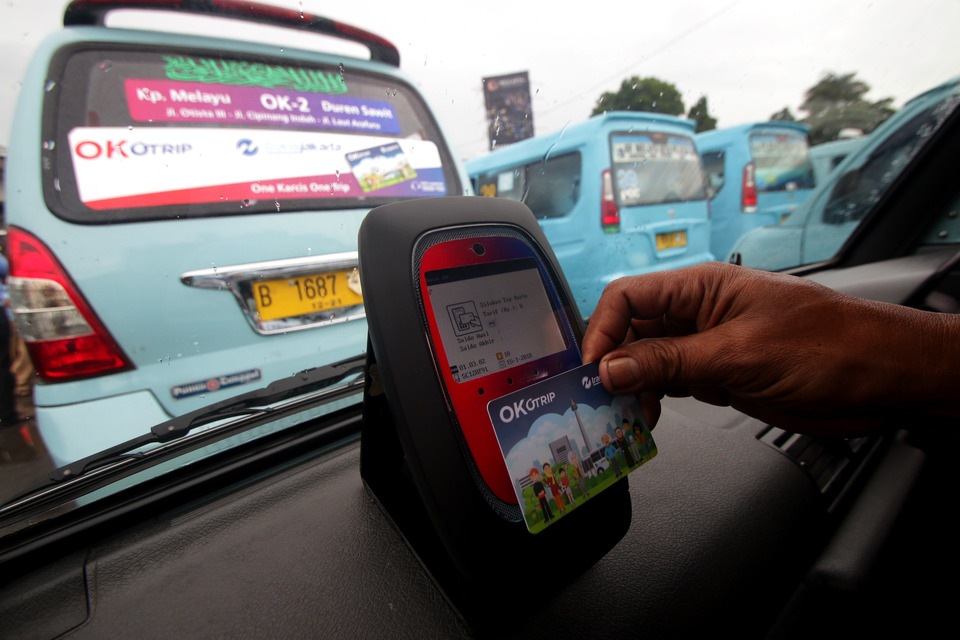 A passenger scans his new OK Otrip card at Kampung Melayu bus terminal in Jakarta on Monday (15/01).
(Antara Photo/Rivan Awal Lingga)