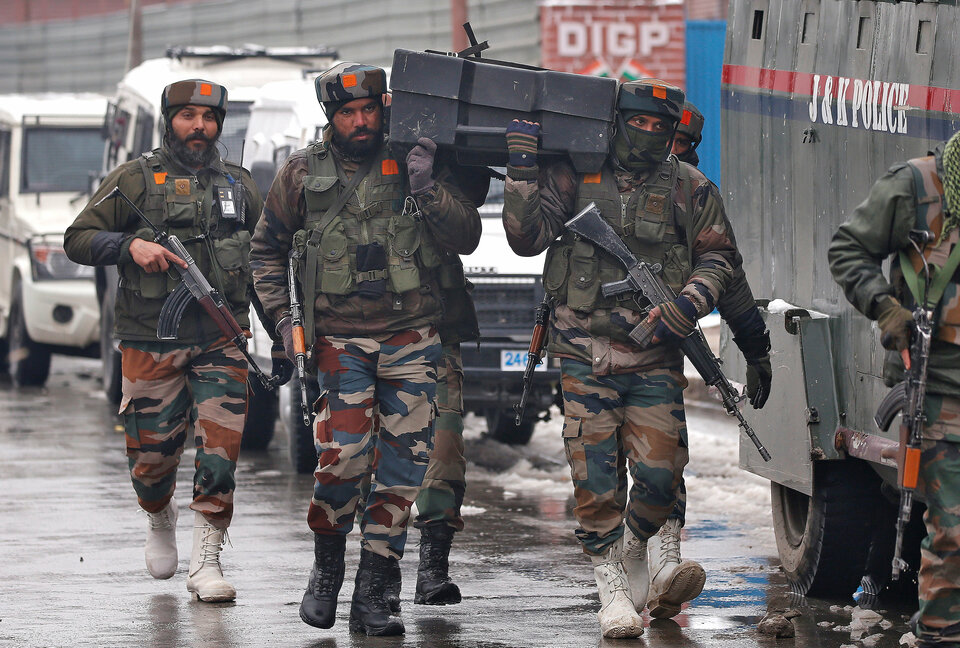 Indian army soldiers carry a box containing bulletproof shields near the site of a gunbattle with suspected militants in Srinagar on Monday (12/02). (Reuters Photo/Danish Ismail)